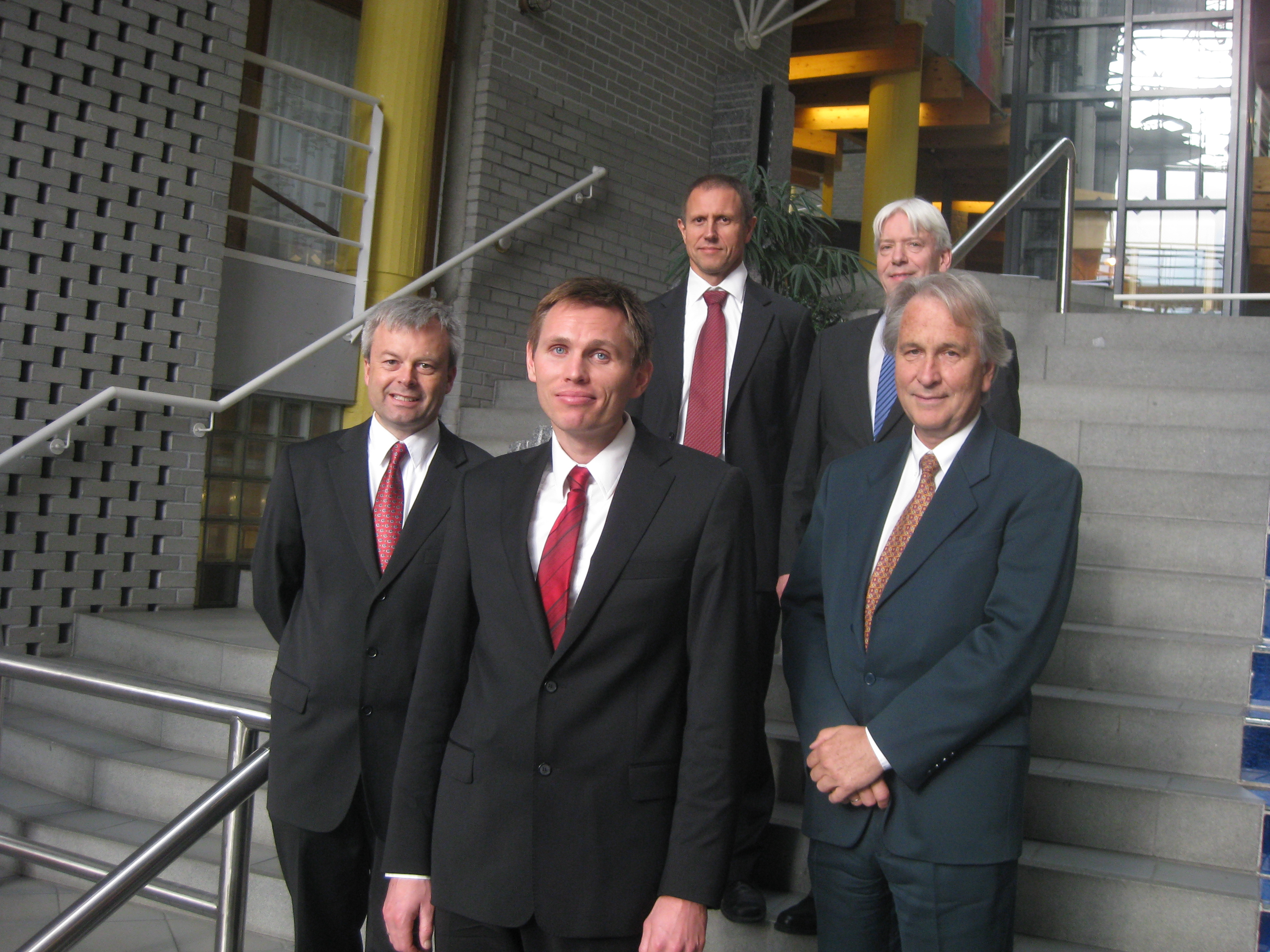 Doktoranden omflanket av disputasleder og bedømmelseskomite