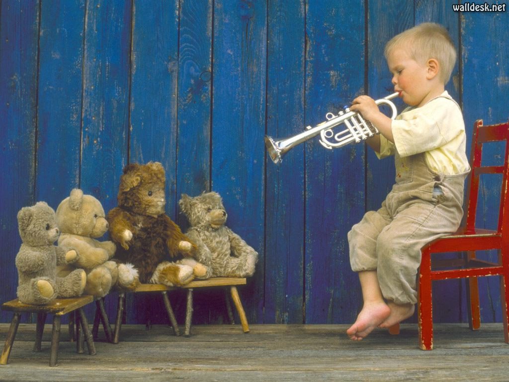 Bilde av liten gutt som spiller trompet for bamsene sine