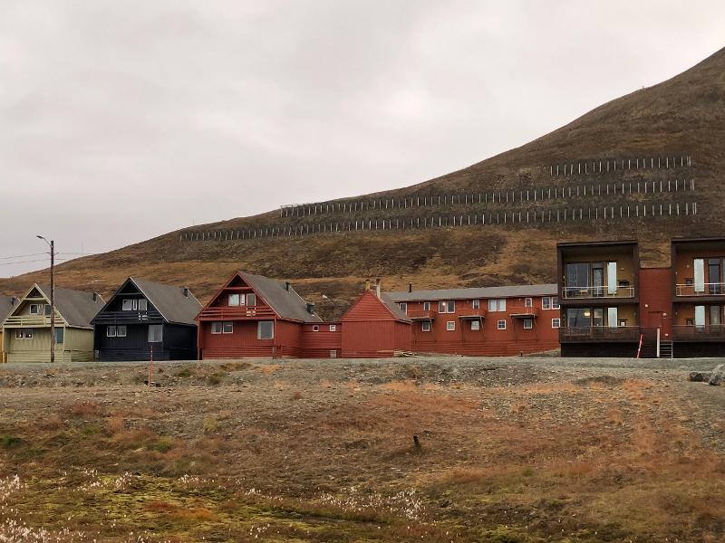 Bak de kjente spisshusene i Longyearbyen gikk det i 2015 et snøskred som krevde to menneskeliv. Derfor er det satt opp skredsikring i lia ovenfor. 