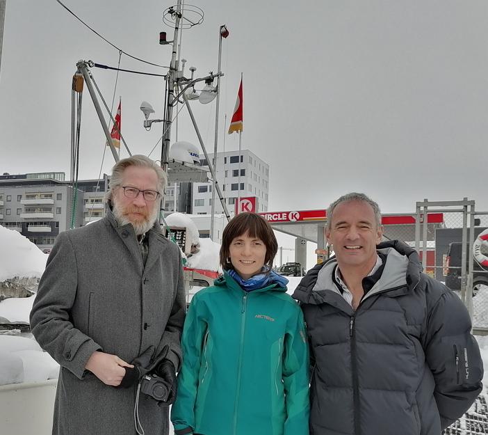 3 people standing infront of a boat in the harbour