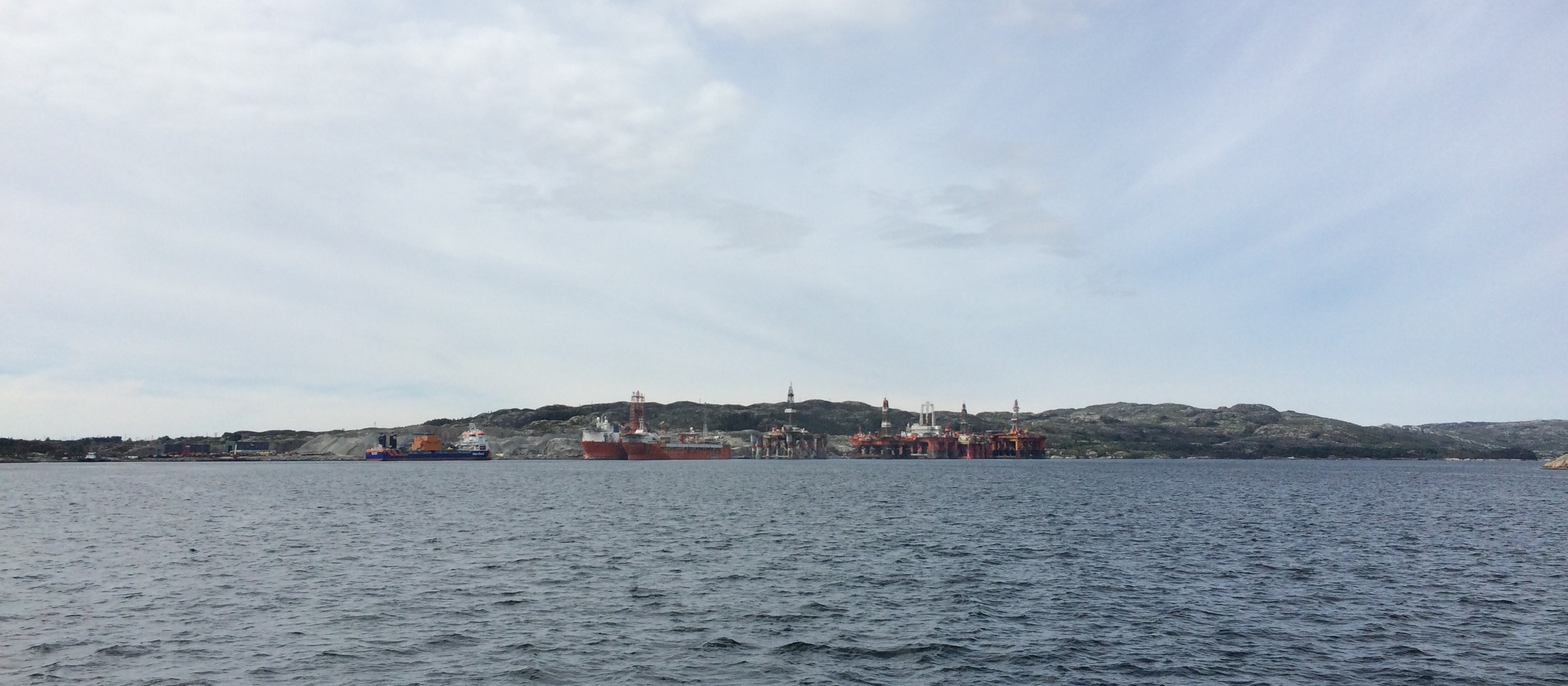 Bildet viser oljeplattformer og supplyskip som ligger til havn