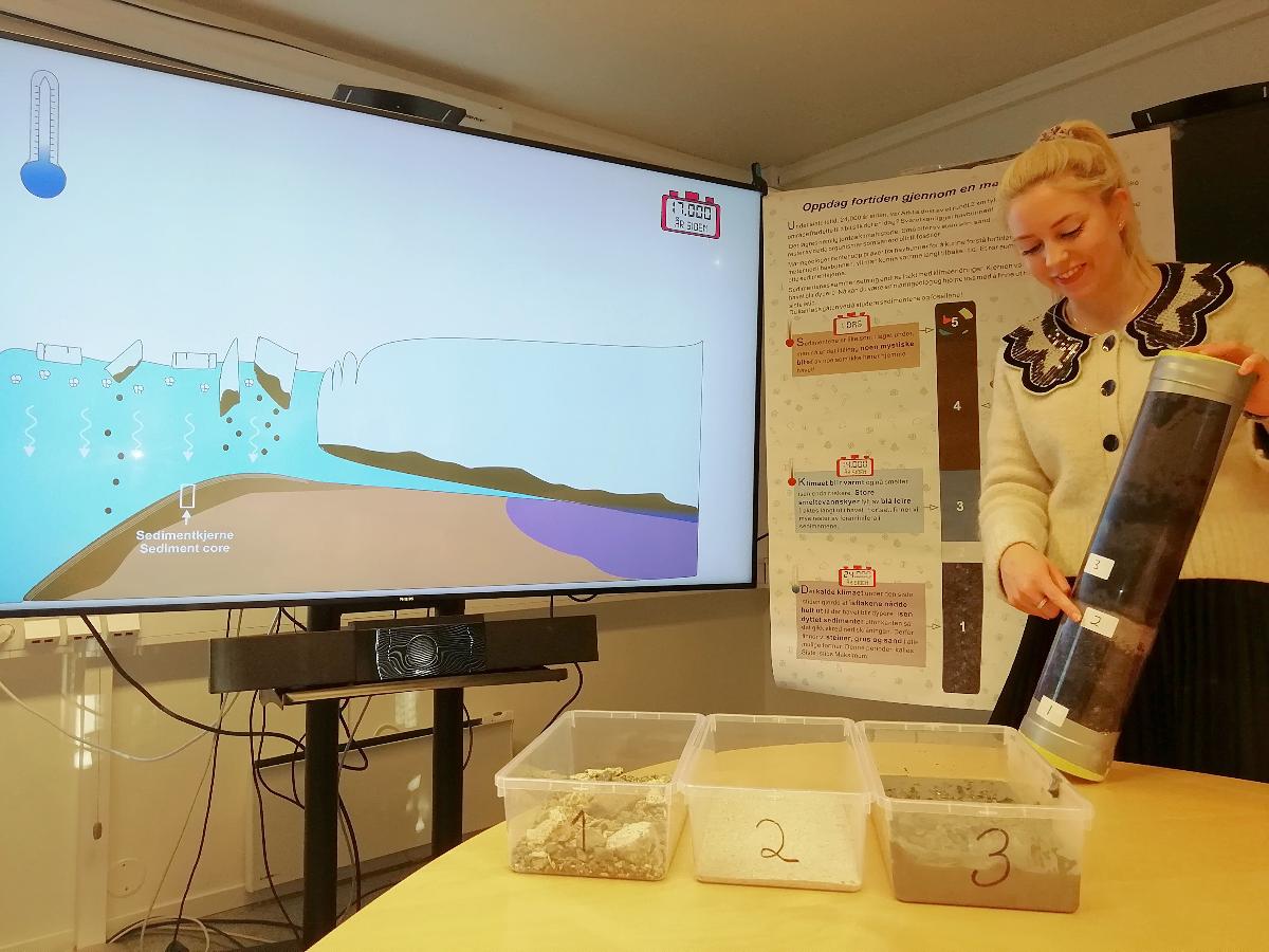 Stine Bjordal Olsen forklarer innholdet i sedimentkjernen hentet fra kontinentalskråningen utenfor Tromsø. Den viser forskjellige lag avsatt under forskjellig påvirkning av isen som dekket Nord-Europa under siste istid.