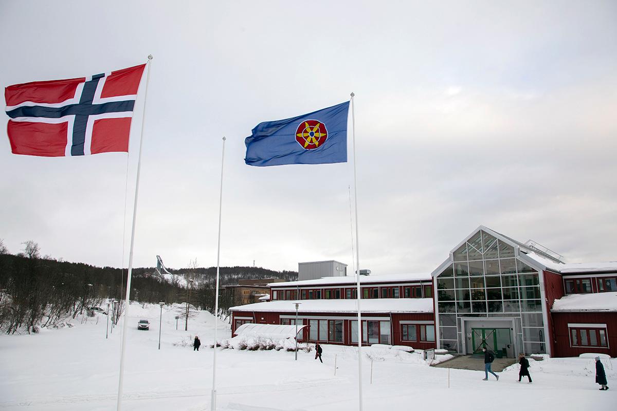 Kvenfolkets flagg og det norske flagget heist på UiT campus Tromsø