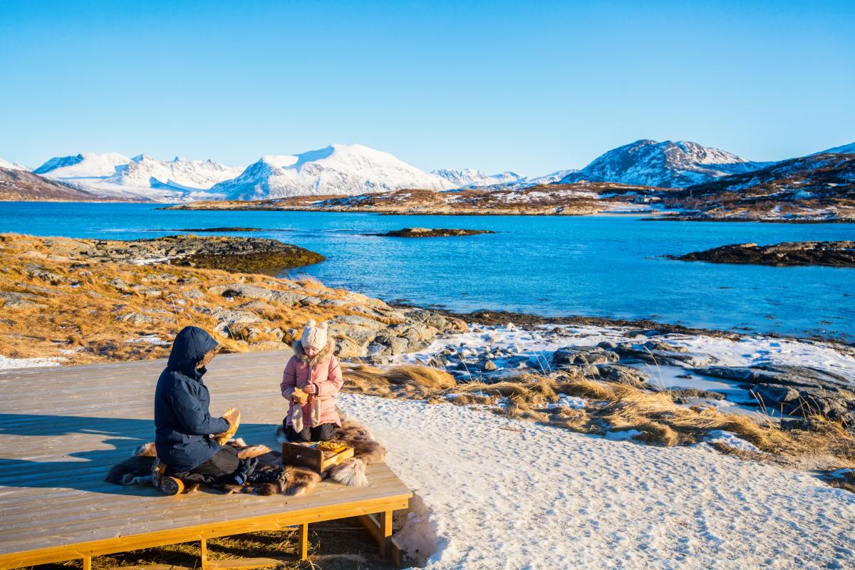 piknik på nordnorsk strand med snø og sol.