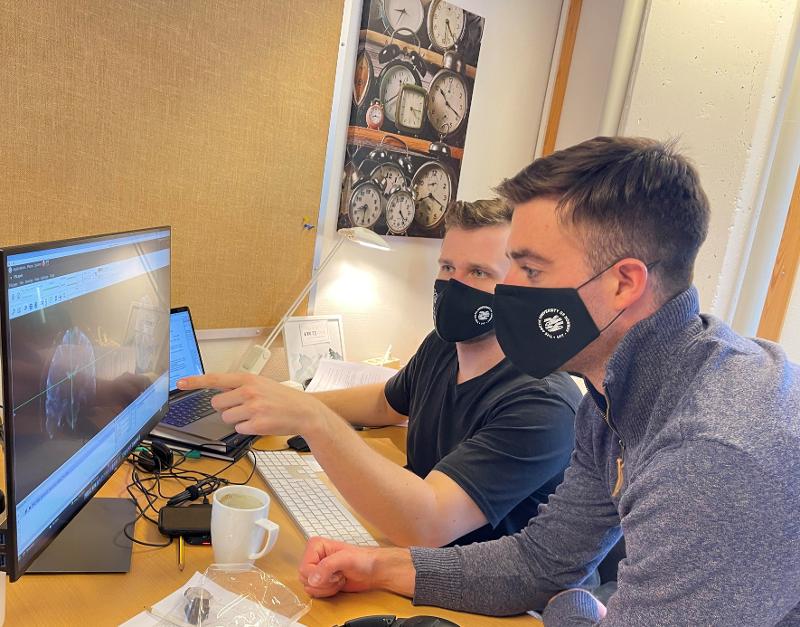 forskere studerer hjernescan-bilder på PC 