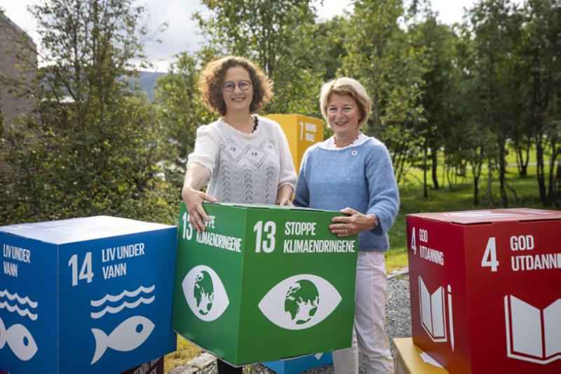 Anne Husebekk og Kristin Røymo med store kuber med FNs bærekraftsmål rundt seg. 