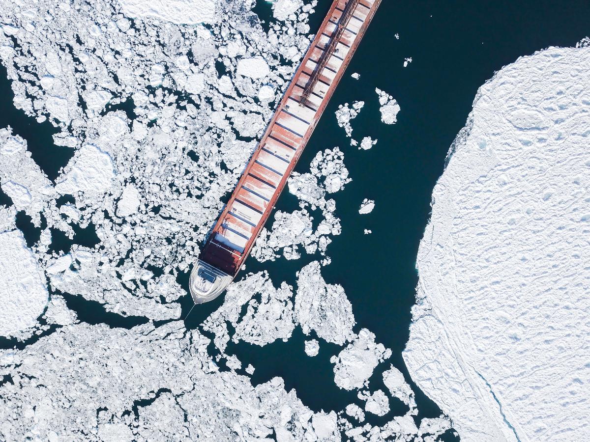 Dronefoto av et langt skip i havisen