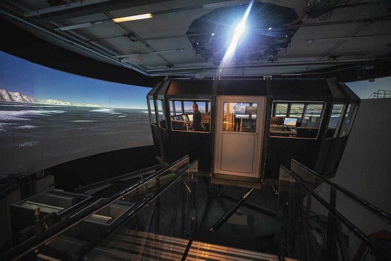 Skipssimulator ved UiT. Styrehus og skjermer som viser hav.