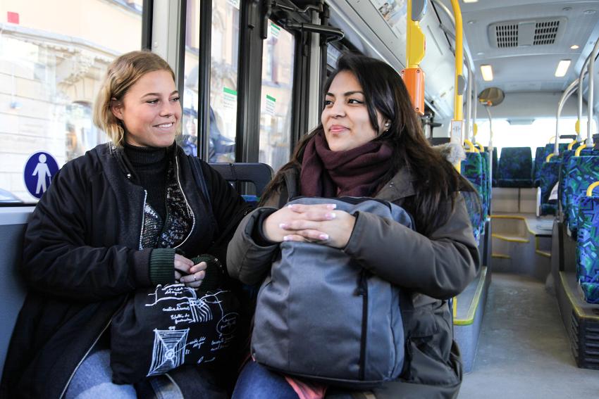 2 kvinner sitter ved siden av hverandre på bussen