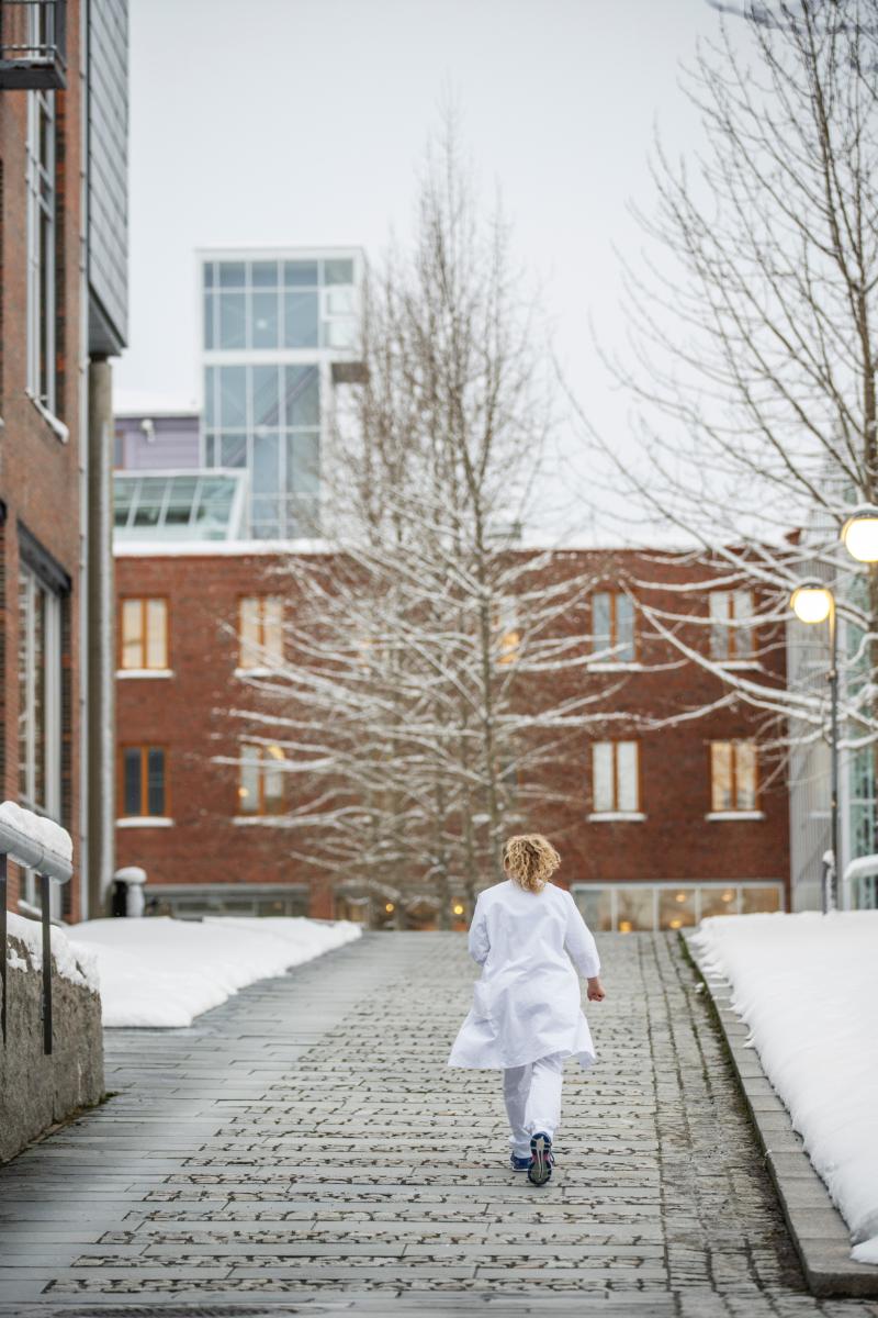 medisinstudent med hvit frakk som går rundt på UiT campus