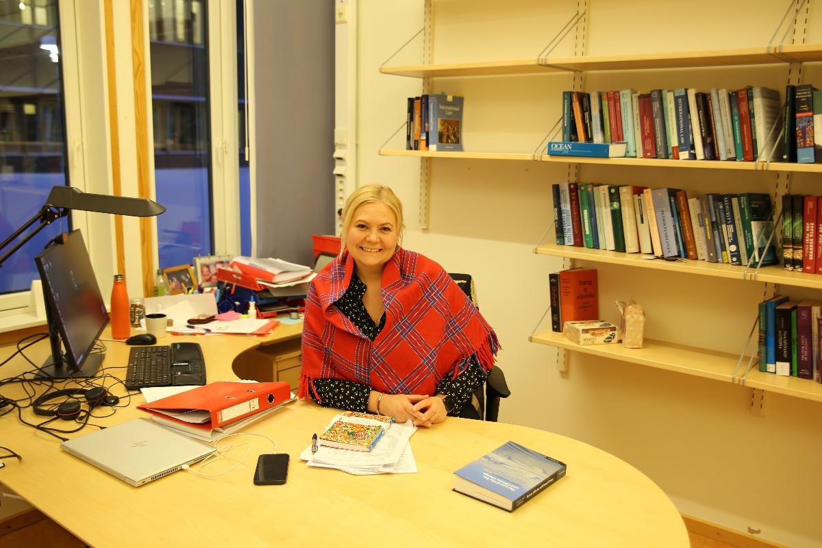 Bilde av Ingvild Ulrikke Jakobsen i profil, hun sitter i kontorstolen og smiler. 