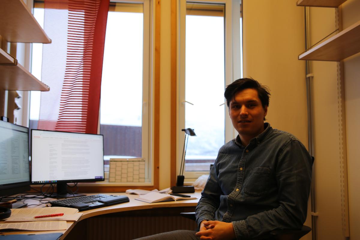 Bilde av Adrian Mathias Nystø Mikkelsen på hans kontor ved det juridiske fakultet.