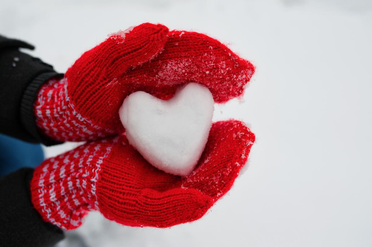 Snø-hjerte holdt av en person med votter