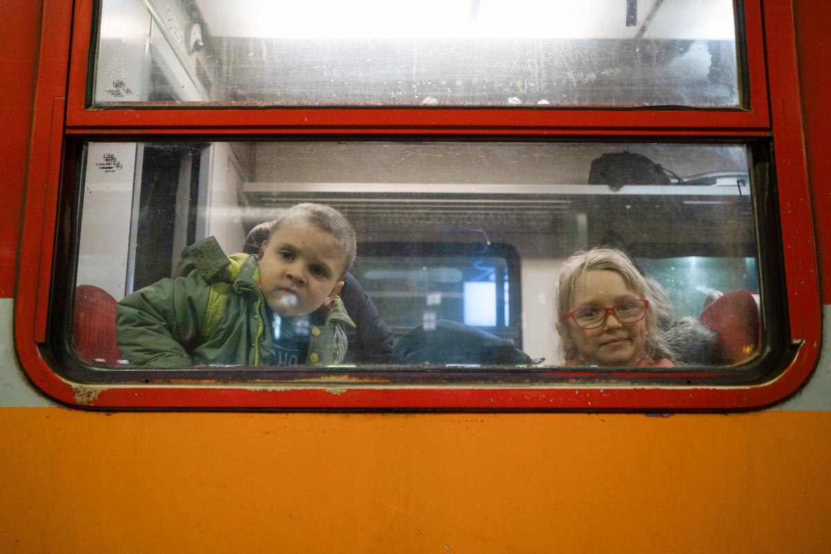 To barn på flukt ser ut av vinduet, på tog på vei fra Ukraina.