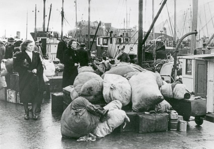 Flyktninger fra Finnmark går ombord i fiskeskøyte under tvangsevakueringen høsten 1944. 