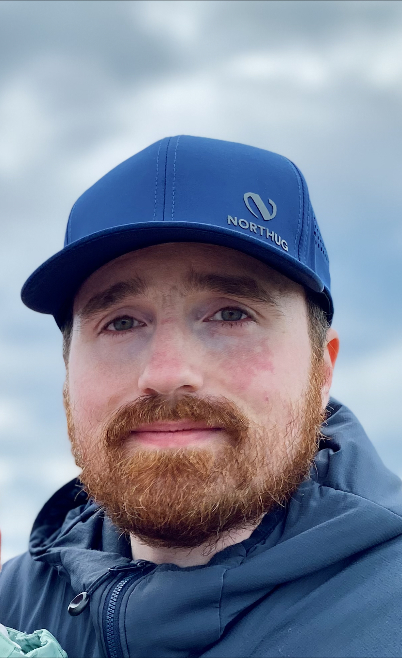 Bilde av Niklas Jonsson i profil, han har på seg en blå caps, han ser ikke fornøyd ut, men heller ikke misfornøyd. 