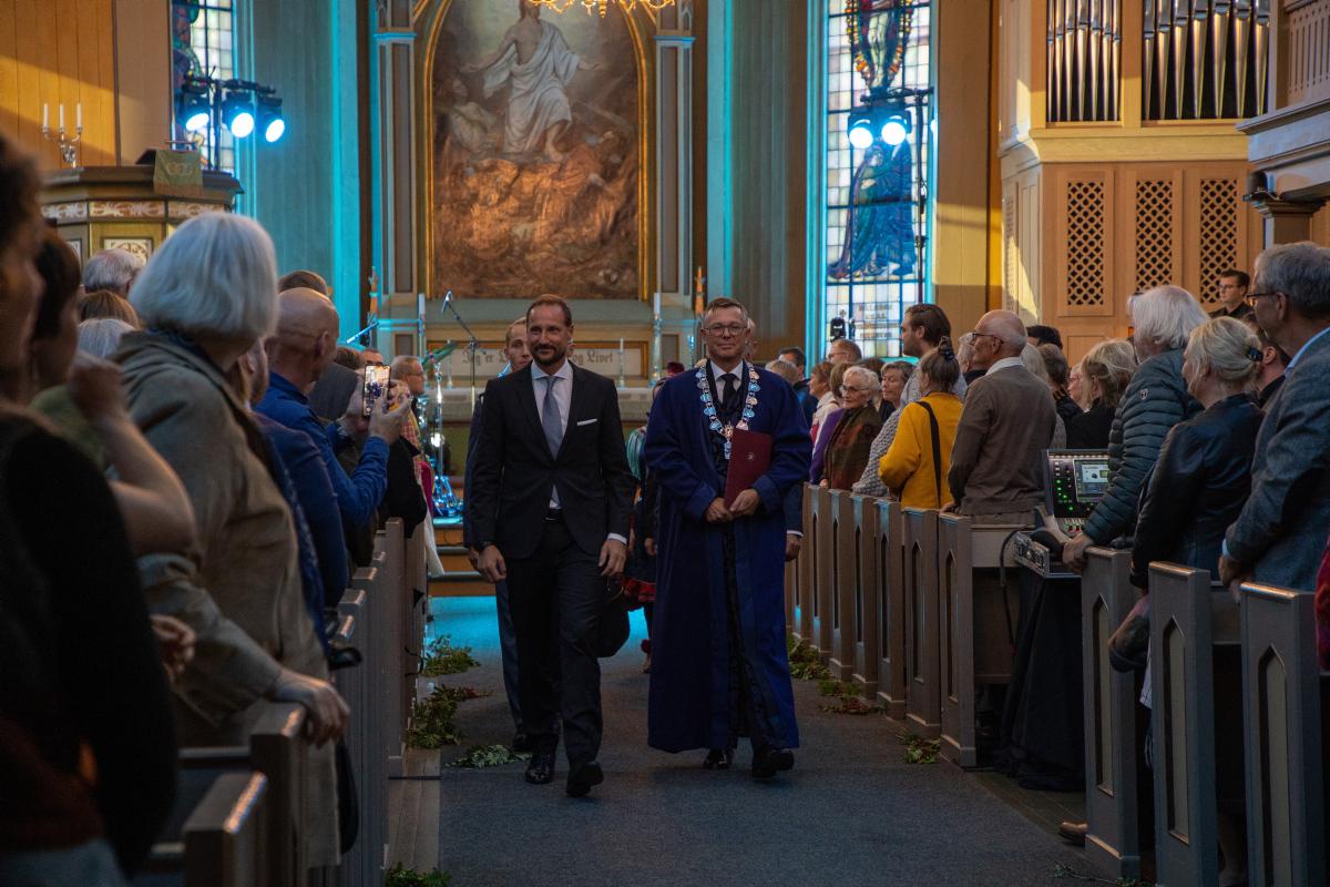 To menn, Den H&oslash;gv&oslash;rde Kronprinsen Haakon og Dag Rune Olsen g&aring;r fremst ut av ei fullsatt  Troms&oslash; Domkyrkje.