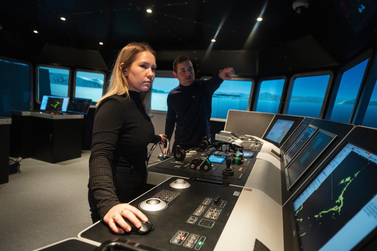 To personer øver på å navigere skip i simulator
