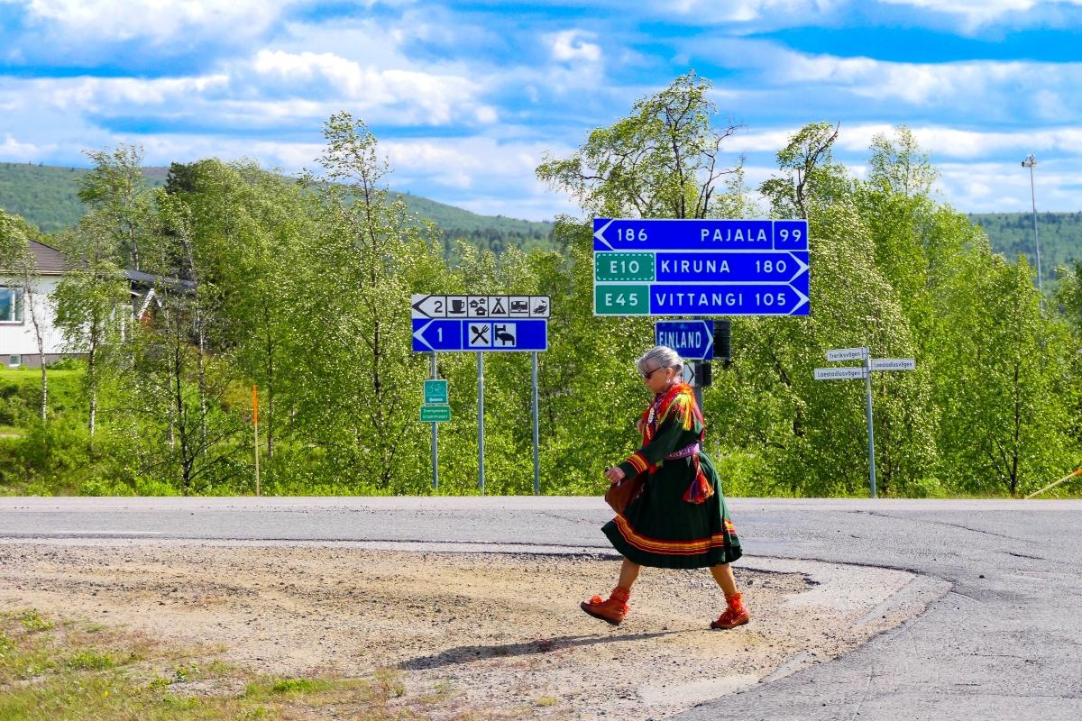 En samisk kvinne går i et veikryss i Karesuando Sverige