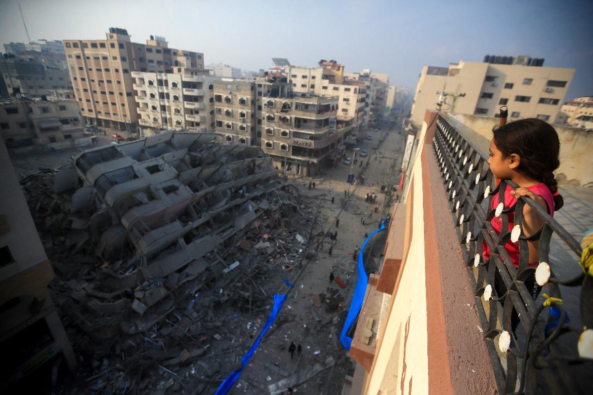 barn som ser på en bygning som er bombet sønder og sammen