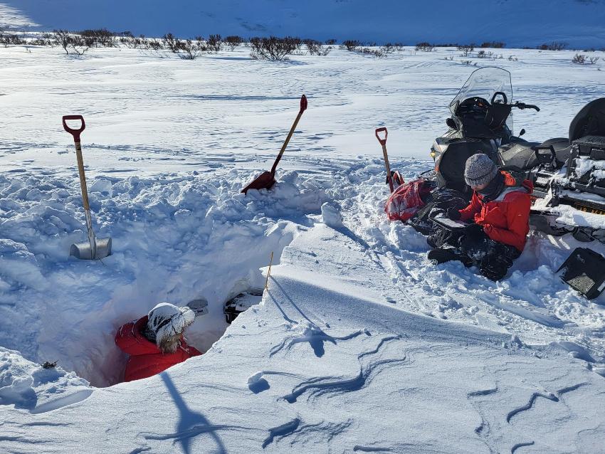 To personer graver dypt i snøen