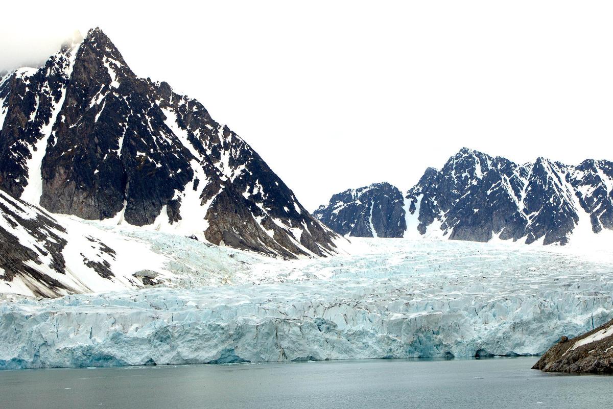 En isbre ligger ned mot ein fjord, omringa av spisse fjell.
