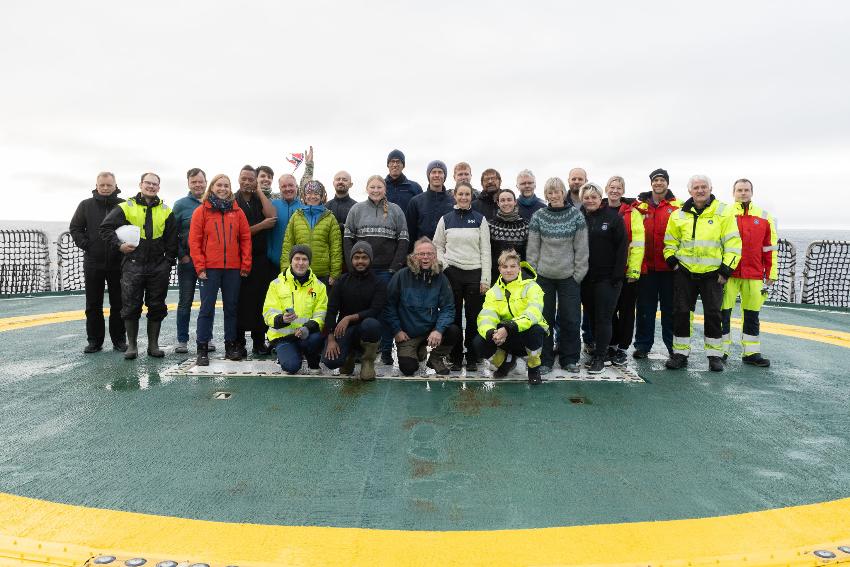 En gruppe mennesker poserer på et helikopterdekk