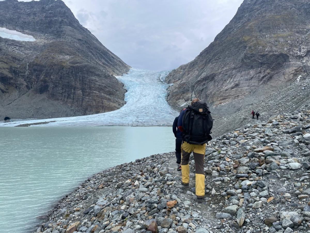 Folk som går i fjellet, på vei mot en isbre.