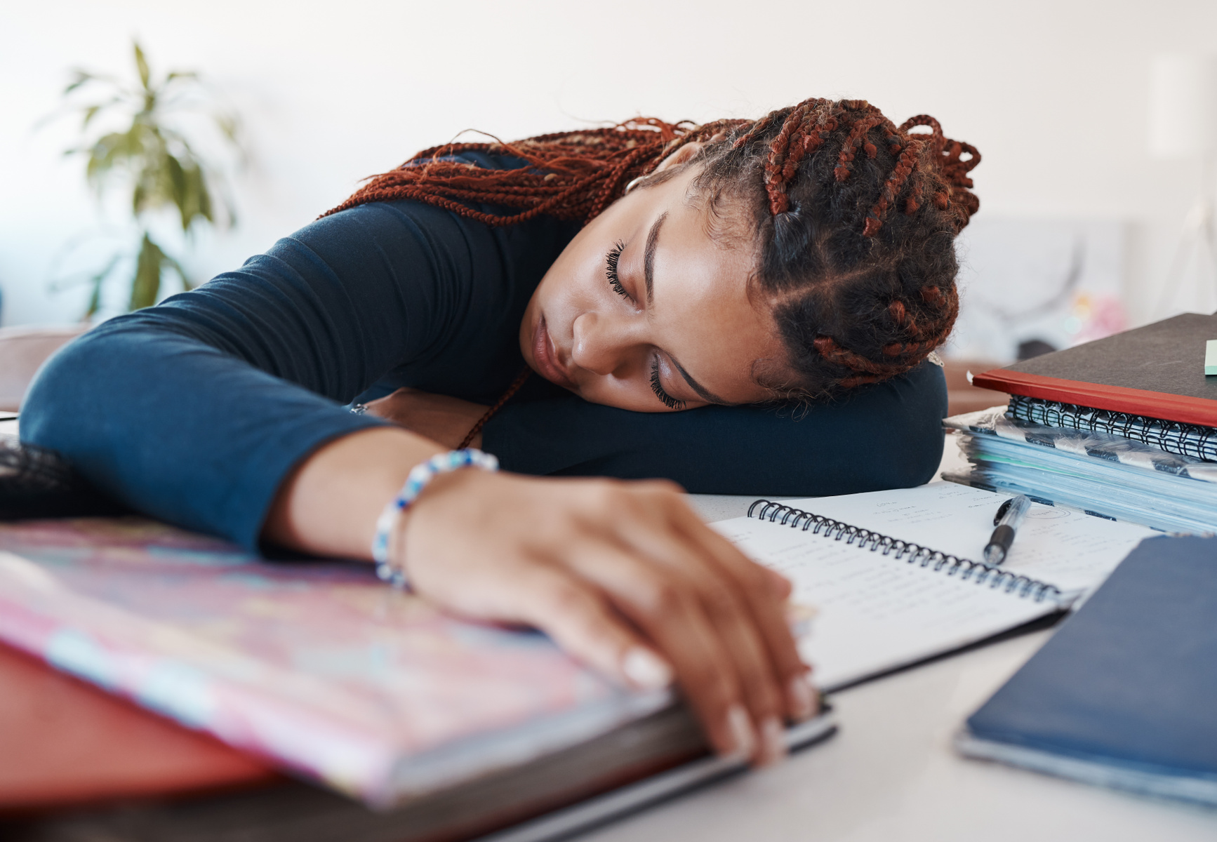 jente som sover oppå skolebøker