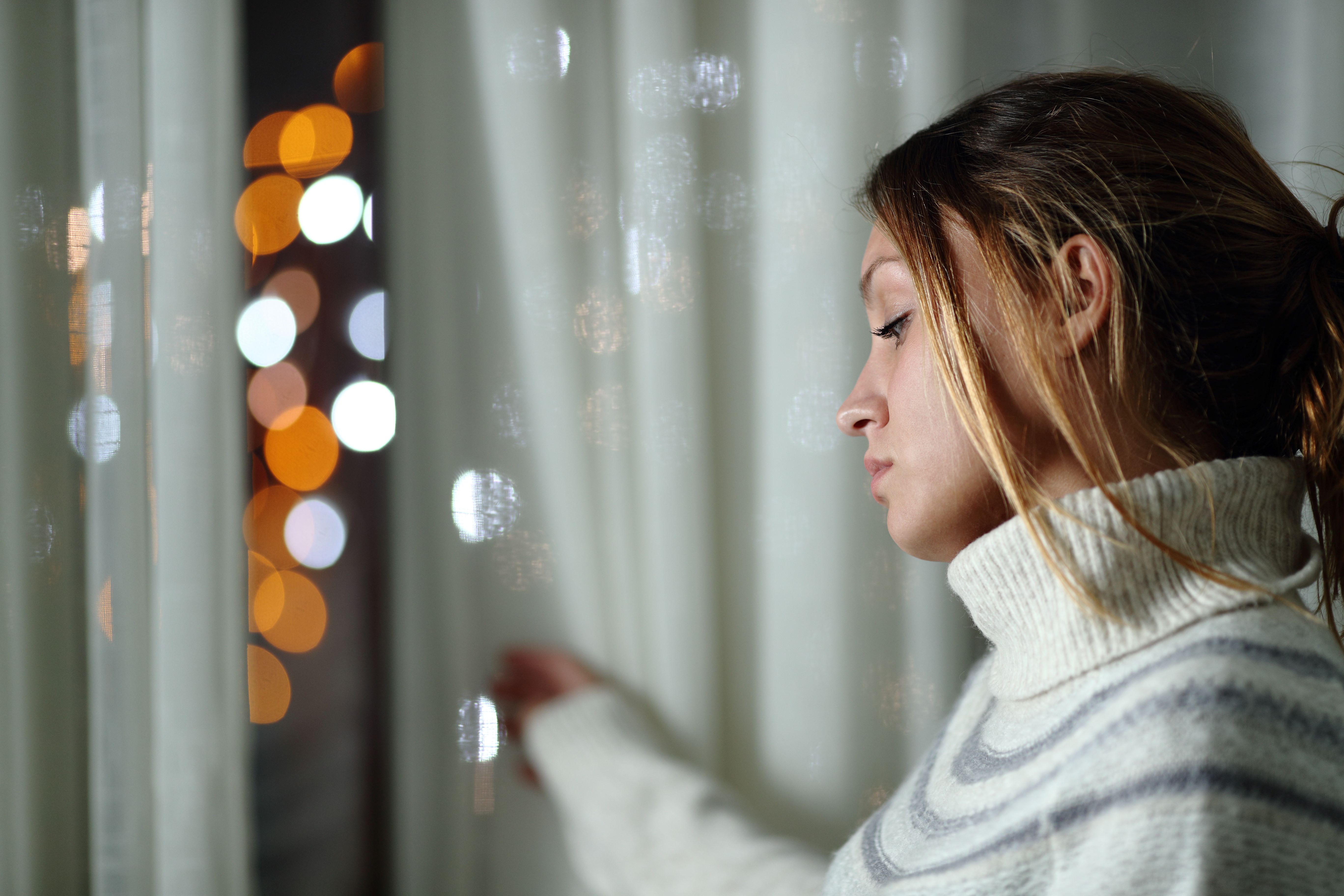 girl looking out window at night