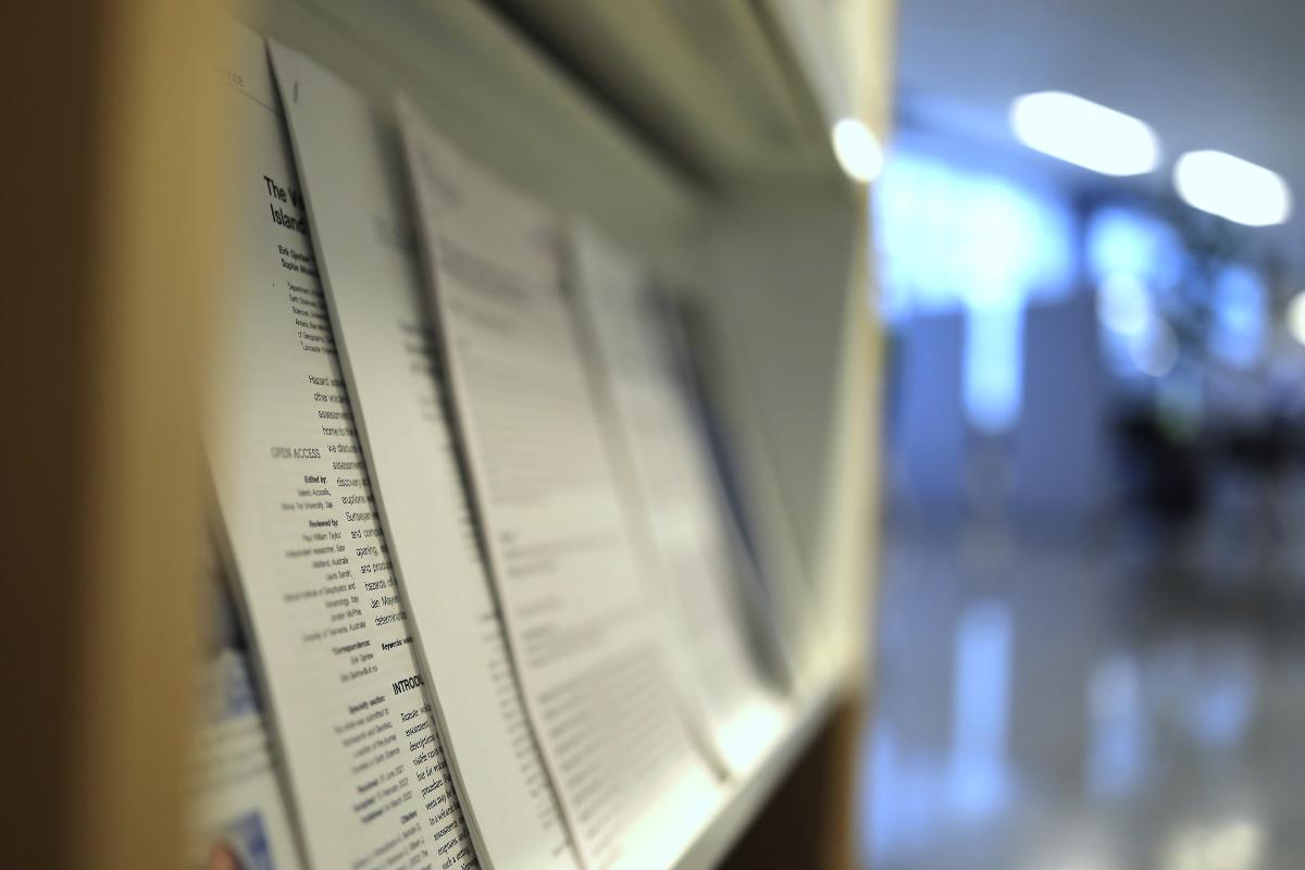 printed research papers on a library shelf