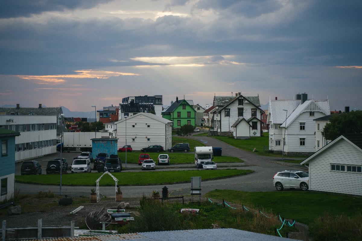 hvite hus og en skolegård under grå skyer