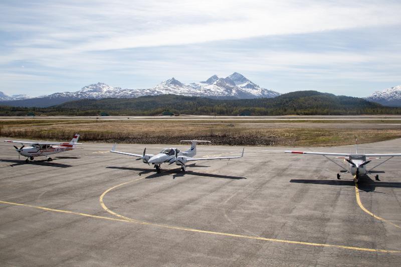 Planes on a tarmac with mountains in the background.