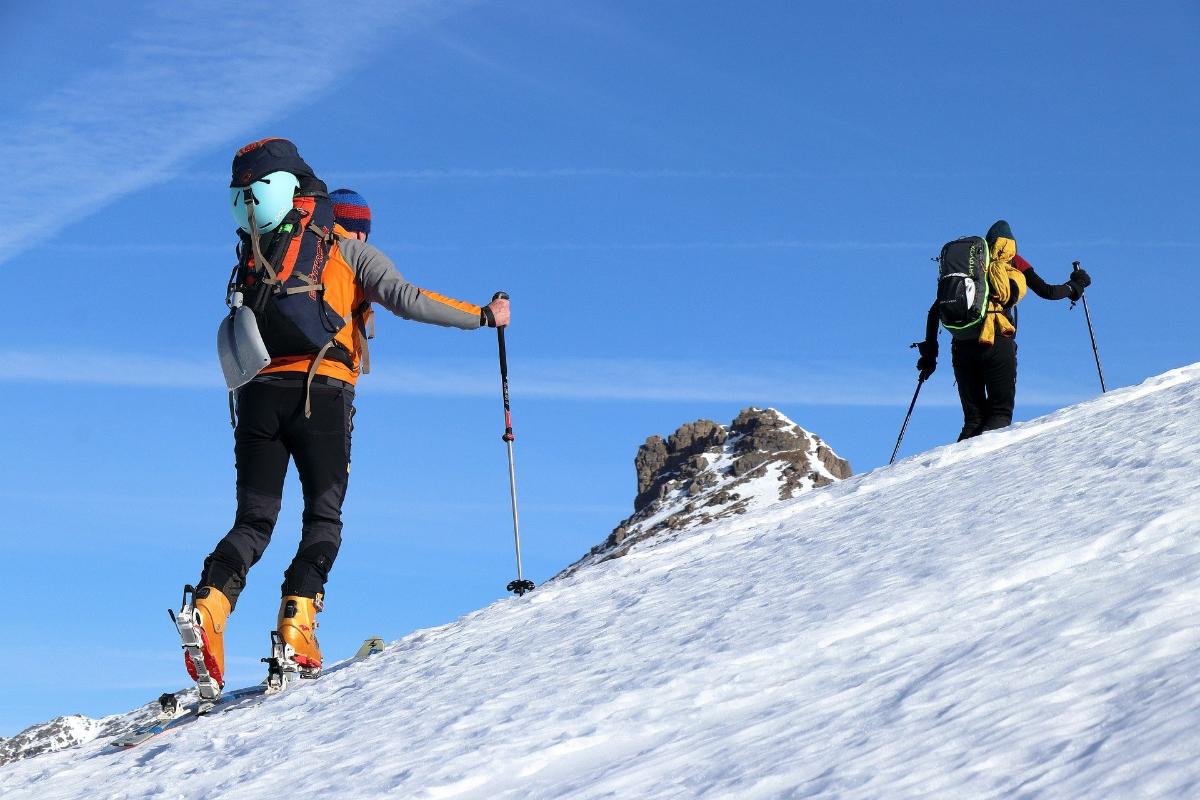 Folk går på ski i bratt terreng