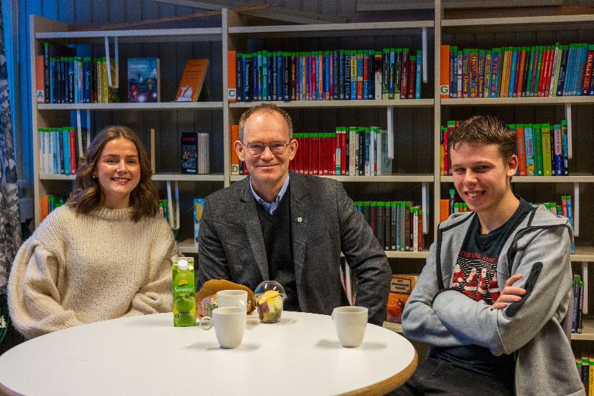 Smilende mennesker på et skolebibliotek