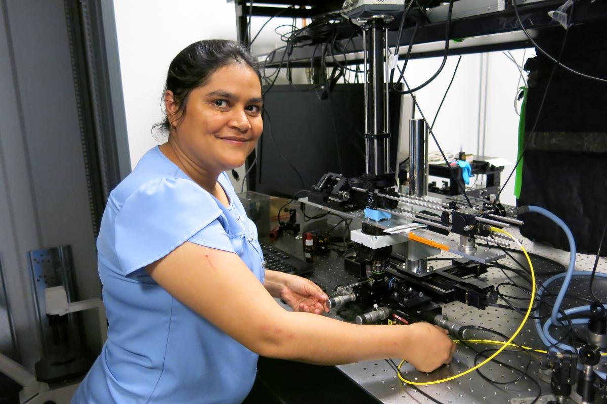 Person standing in an lab for optical technology.