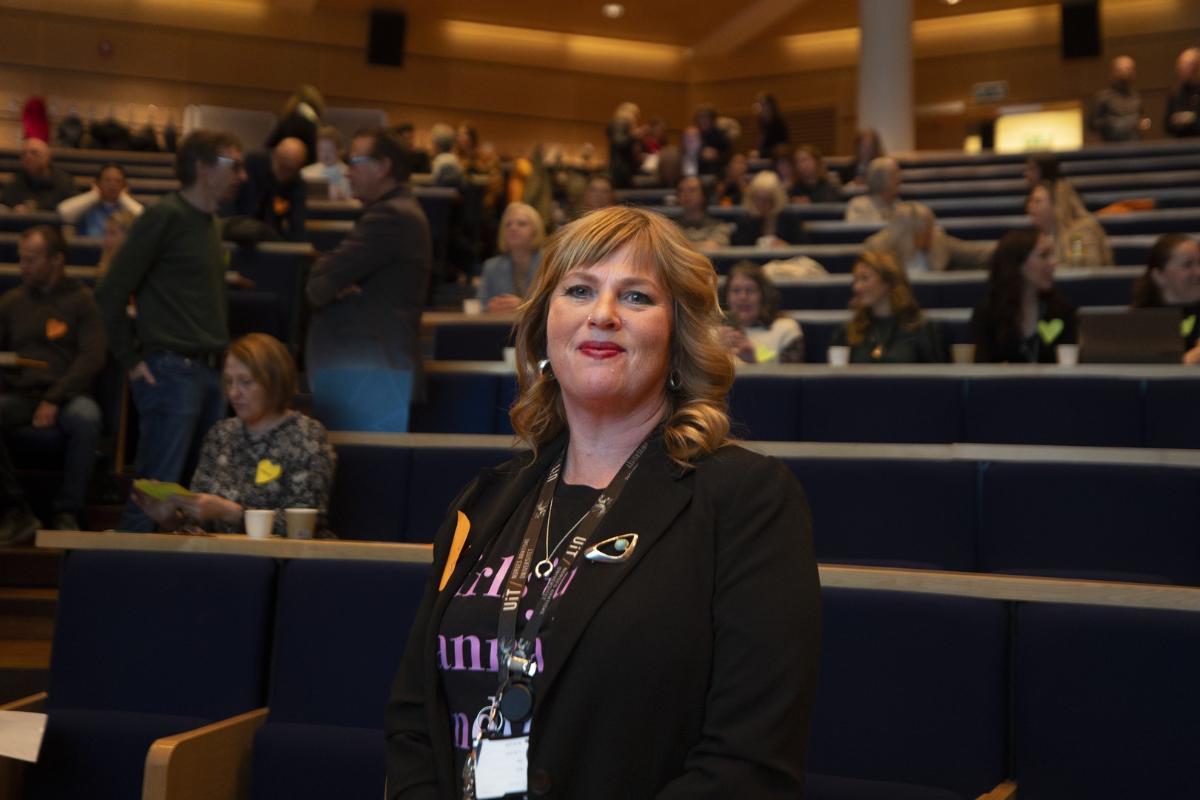 Kvinne i forelesningssal med en del publikum. 