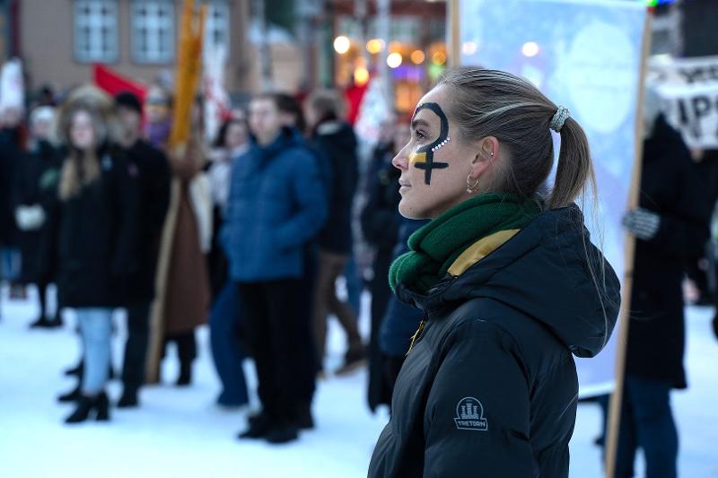 Kvinne med ansiktsmaling på et torg under en 8. mars-markering