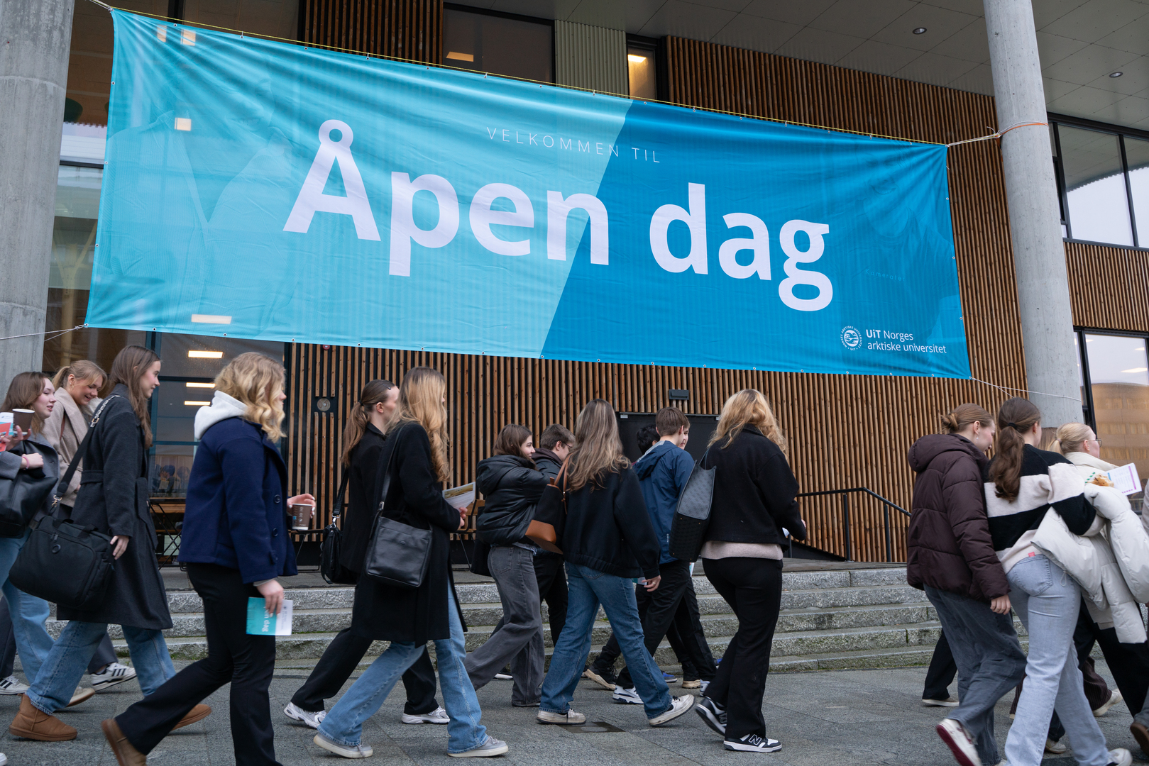 Studenter som går forbi et banner der det står Åpen dag.