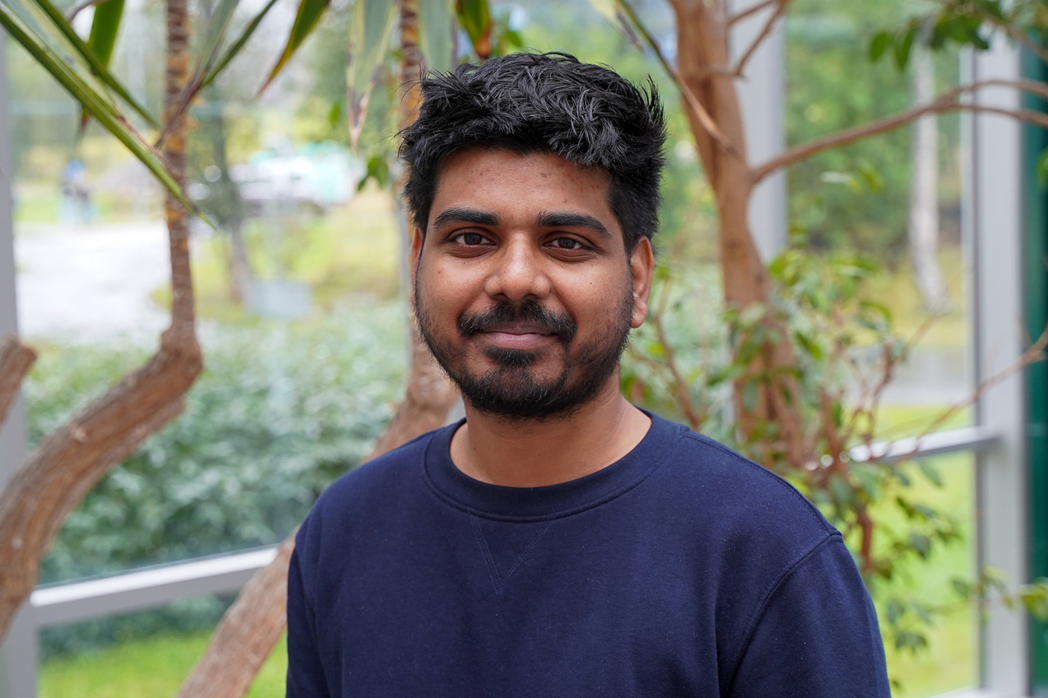 En mann ser mot kameraet og smiler