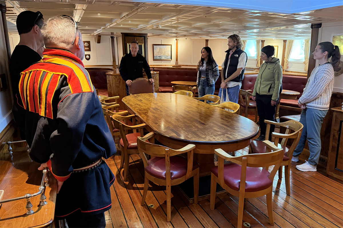 Personer står rundt et bord