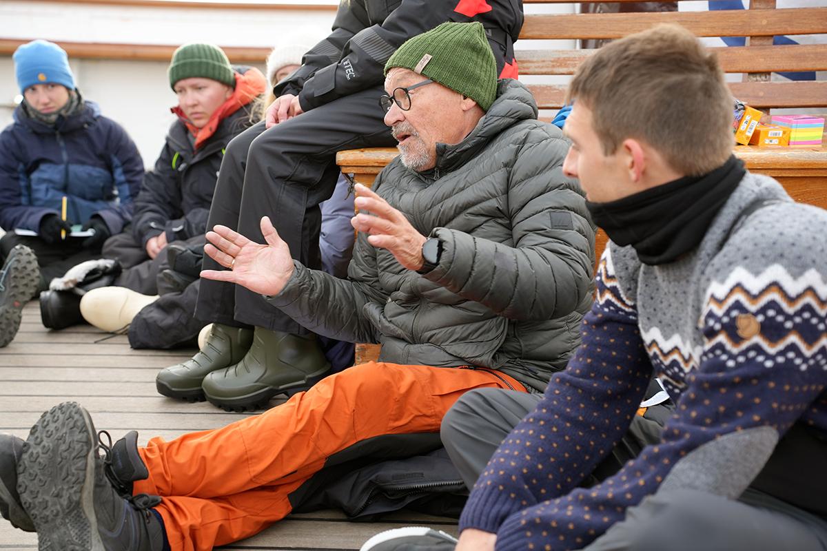 En gruppe mennesker sitter sammen, og det er en som snakker.