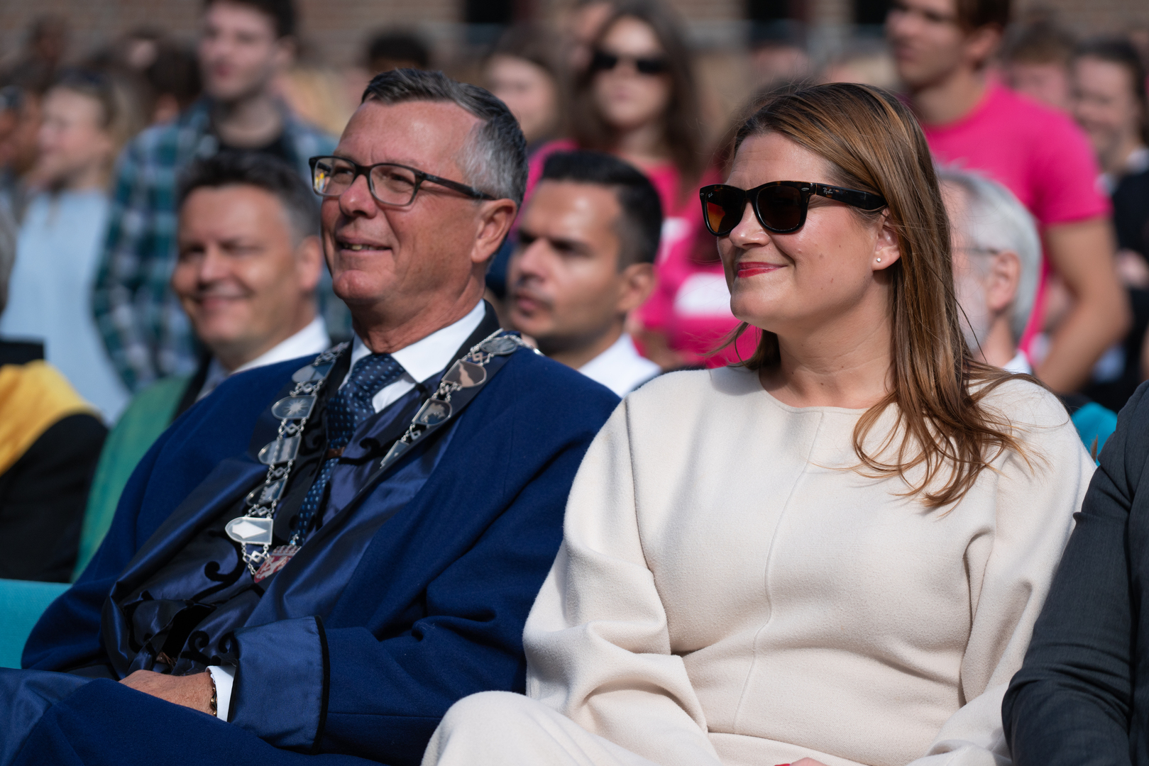 Dag_Rune_Olsen_og_Cecilie_Myrseth_UIT_29141_Foto_Jorn_Berger_Nyvoll.jpg Mann i dress og kvinne i hvitt og med solbriller sitter ved siden av hverandre.