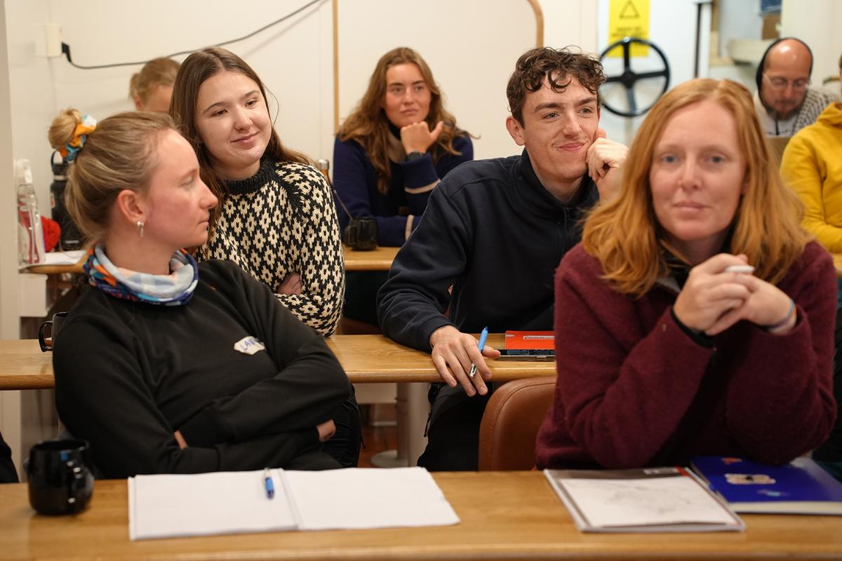 Personer sitter i et klasserom