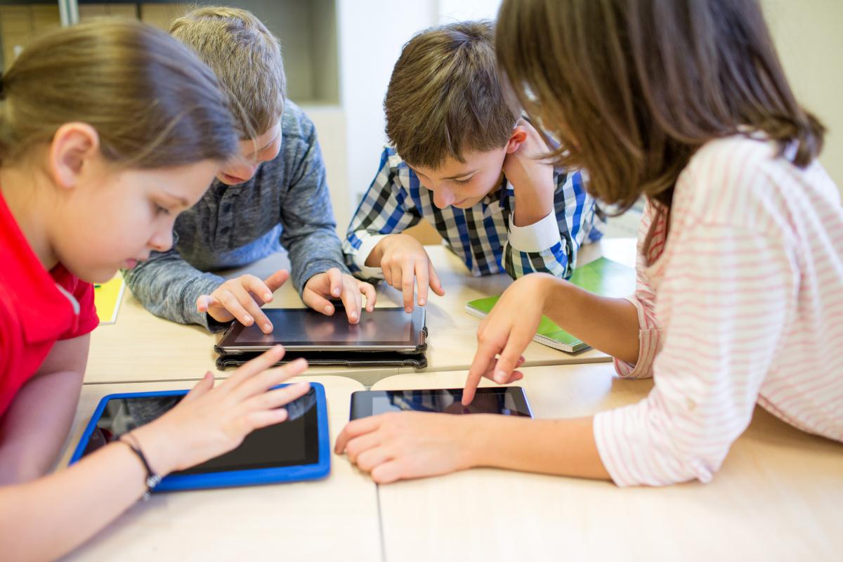 mp10676286-group-of-school-kids-with-tablet-pc-in-classroom.jpg Barn som jobber sammen på skolen.