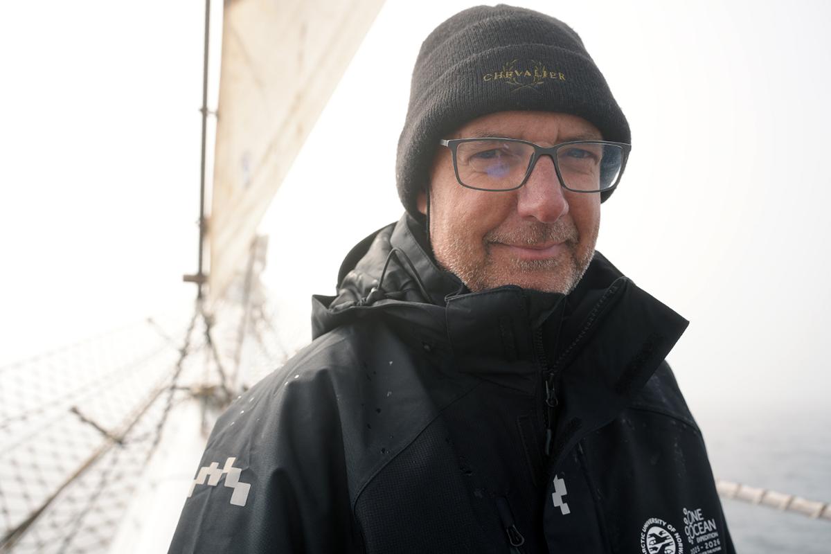 Portrett av en person som ser i kamera med seil bak. 