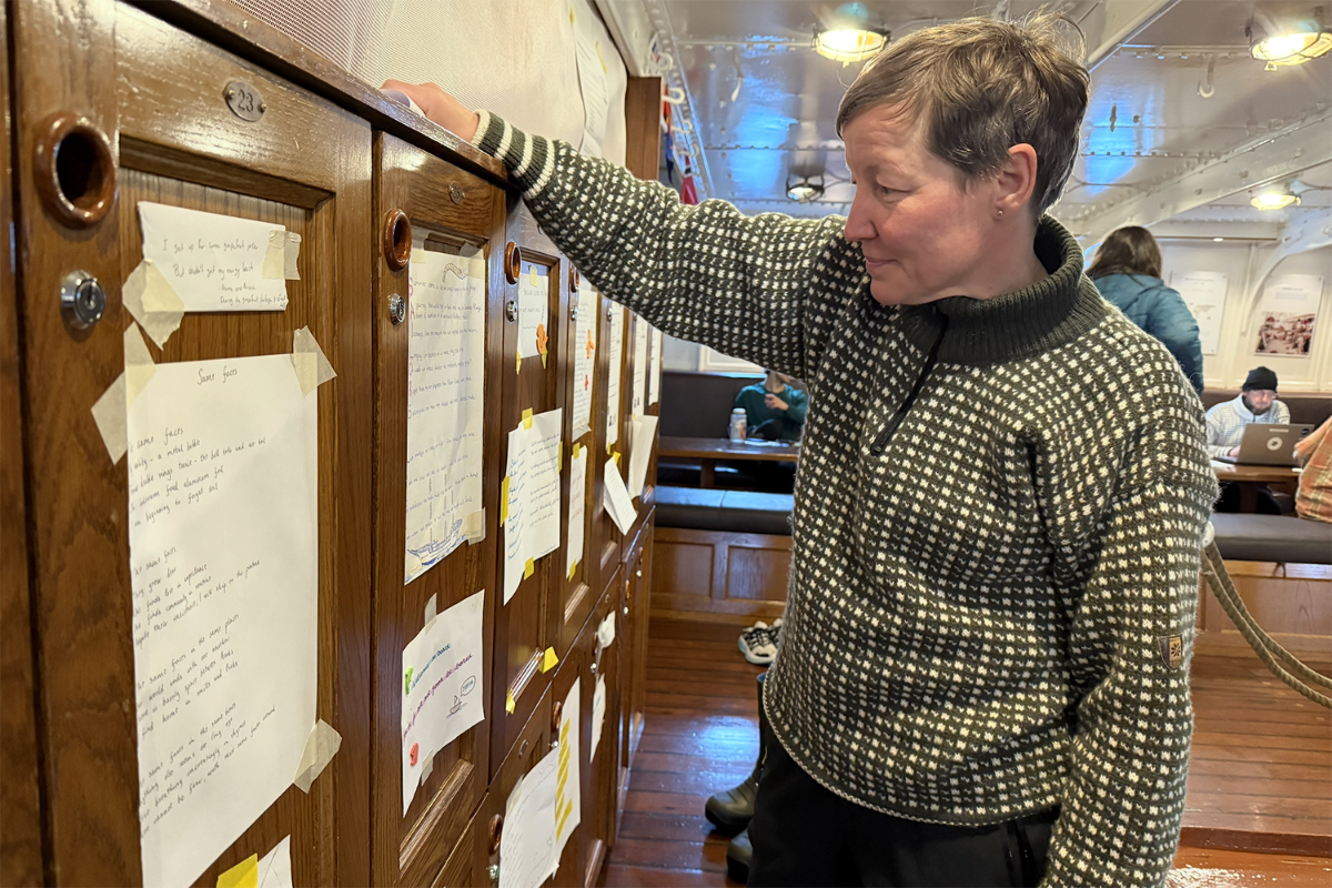 Person leser på papirer som henger på skapdører.