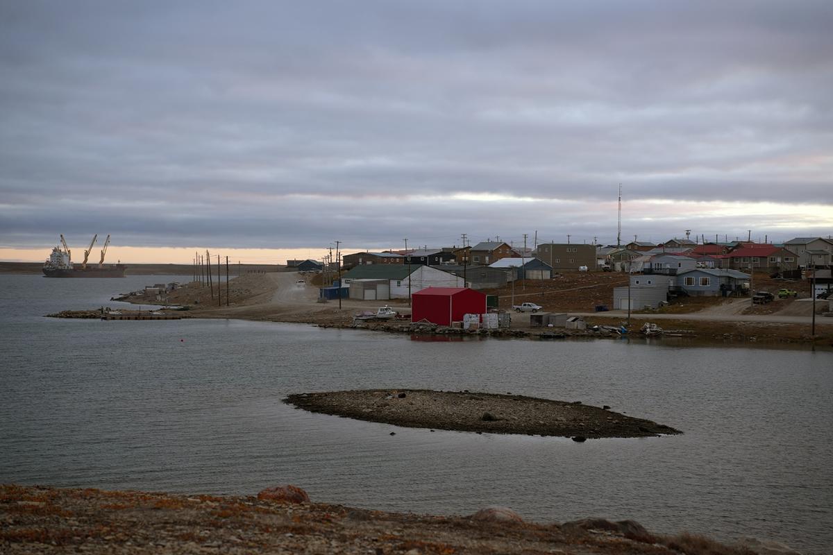 Hus på avstand og vann i forgrunnen