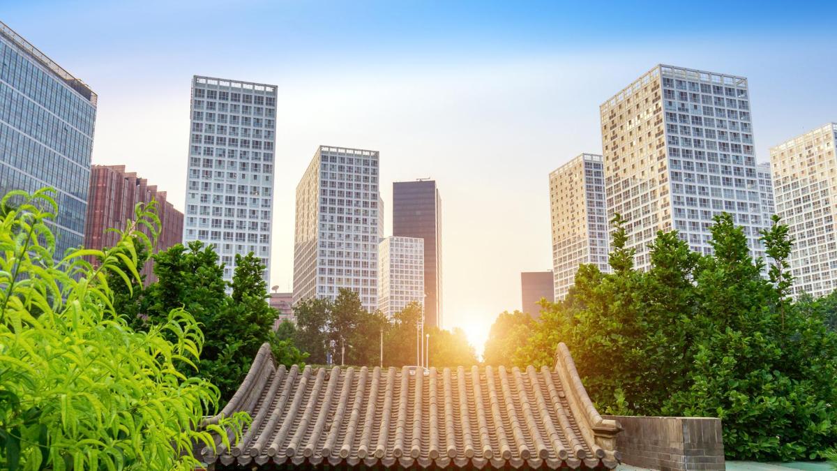 A traditional Chinese building surrounded by skyscrapers.