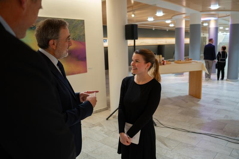 Varaordfører i Tromsø kommune Line Solbakken (t.h) i samtale med Italias ambassadør i Norge Stefano Nicoletti (t.v). Prorektor Jørgen Berge står i forgrunnen. Bak varaordføreren er det et bord med marsipankake og kaffe.